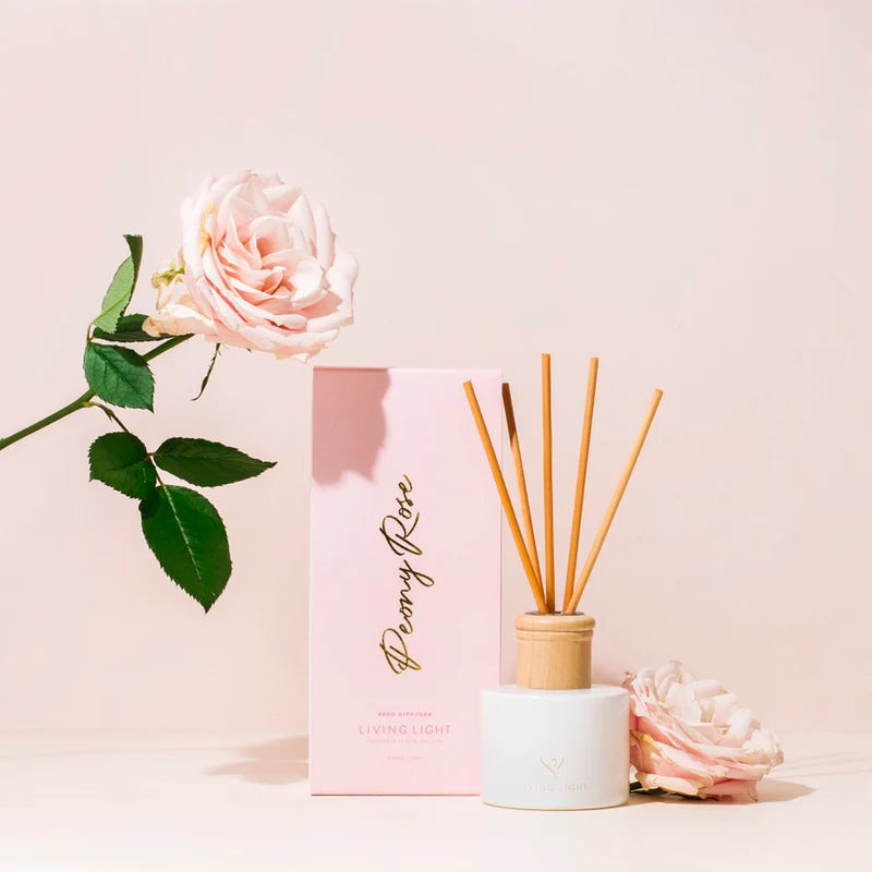 A peony rose scented reed diffuser presented in a white glass bottle with natural wooden cap, which comes in a baby pink box. Made in New Zealand by Living Light.
