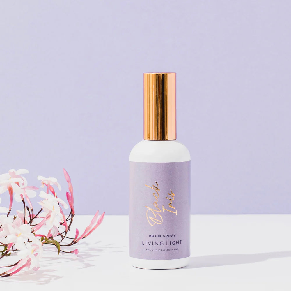 A black iris scented room spray fragrance, presented in a white glass bottle, with gold cap. Made in New Zealand by Living light.
