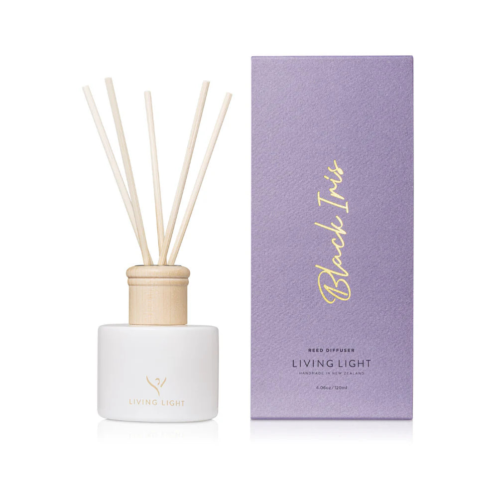 A black iris scented reed diffuser made by Living Light in New Zealand, presented in a white glass bottle with natural wooden cap, which comes in a iris purple coloured box. 