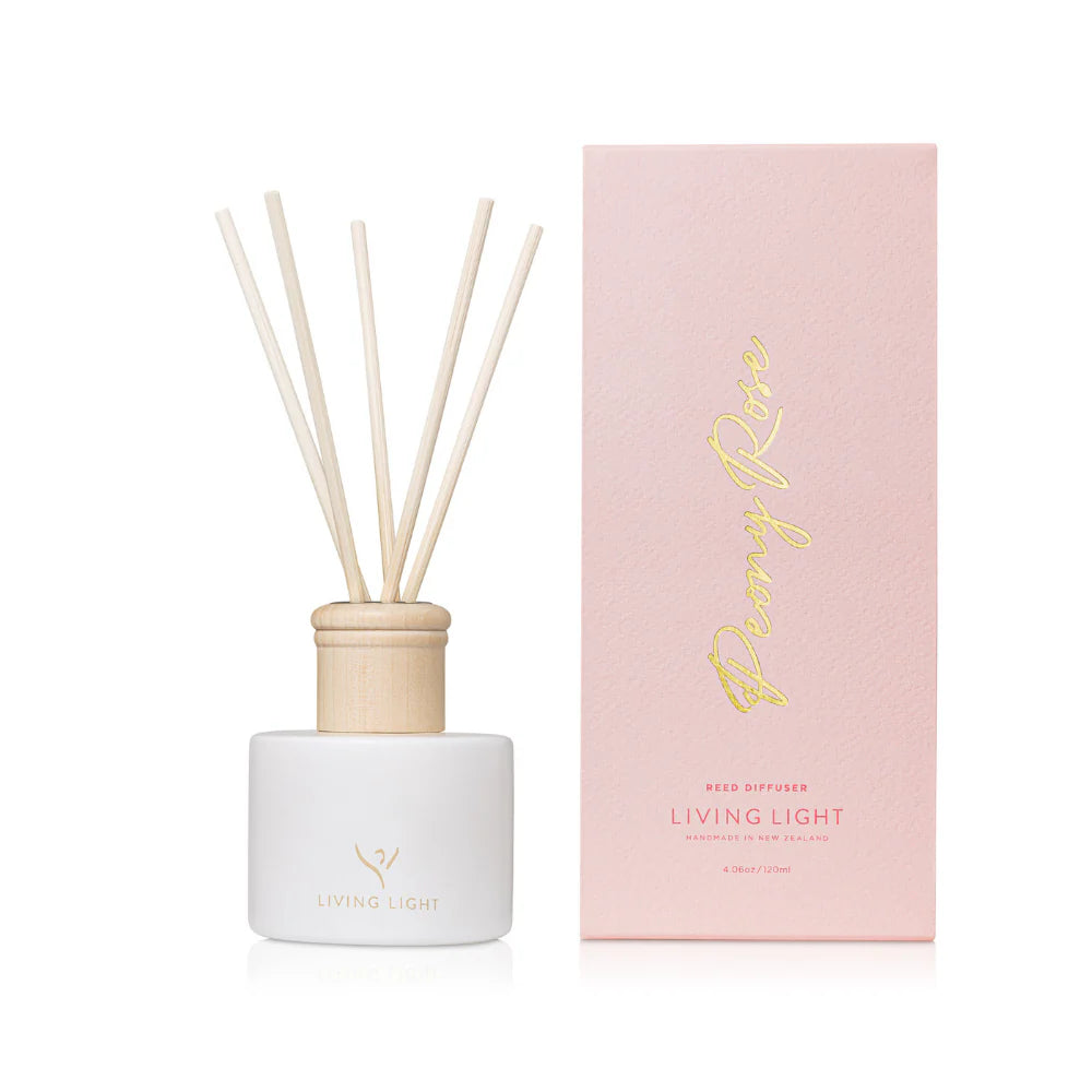 A peony rose scented reed diffuser made by Living Light in New Zealand, presented in a white glass bottle with natural wooden cap, which comes in a baby pink coloured box. 