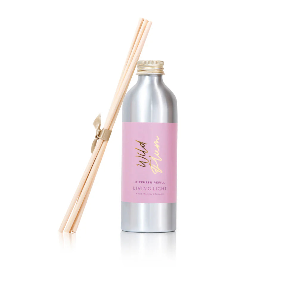 A bottle of wild plum scented diffuser refill and replacement reed sticks, made by living light in New Zealand.